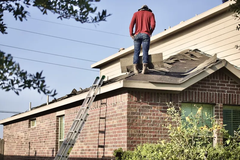 Professional roofer working on a residential roof in De La Plaine Manor